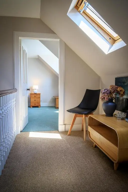 a room with a skylight and a chair and a table at Cosy Cottage in Fishertown, Nairn - Free Parking & Pets welcome in Nairn