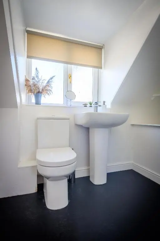 a white bathroom with a sink and a toilet at Cosy Cottage in Fishertown, Nairn - Free Parking & Pets welcome in Nairn