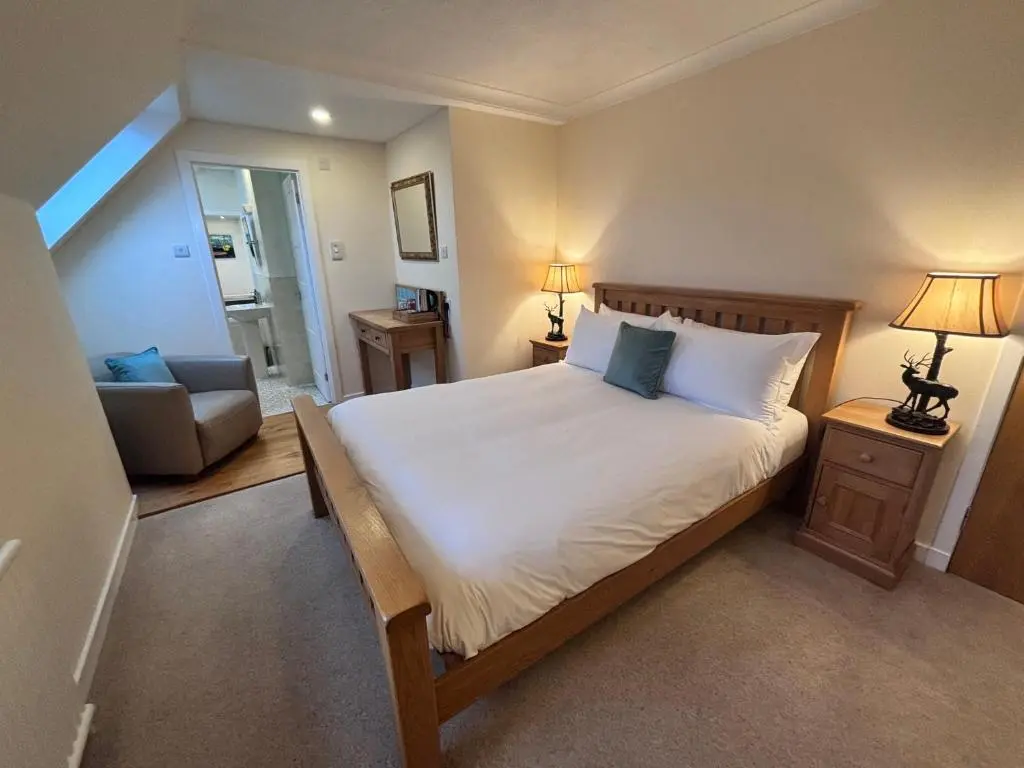a bedroom with a large bed and a couch at The Ullapool Rooms in Ullapool