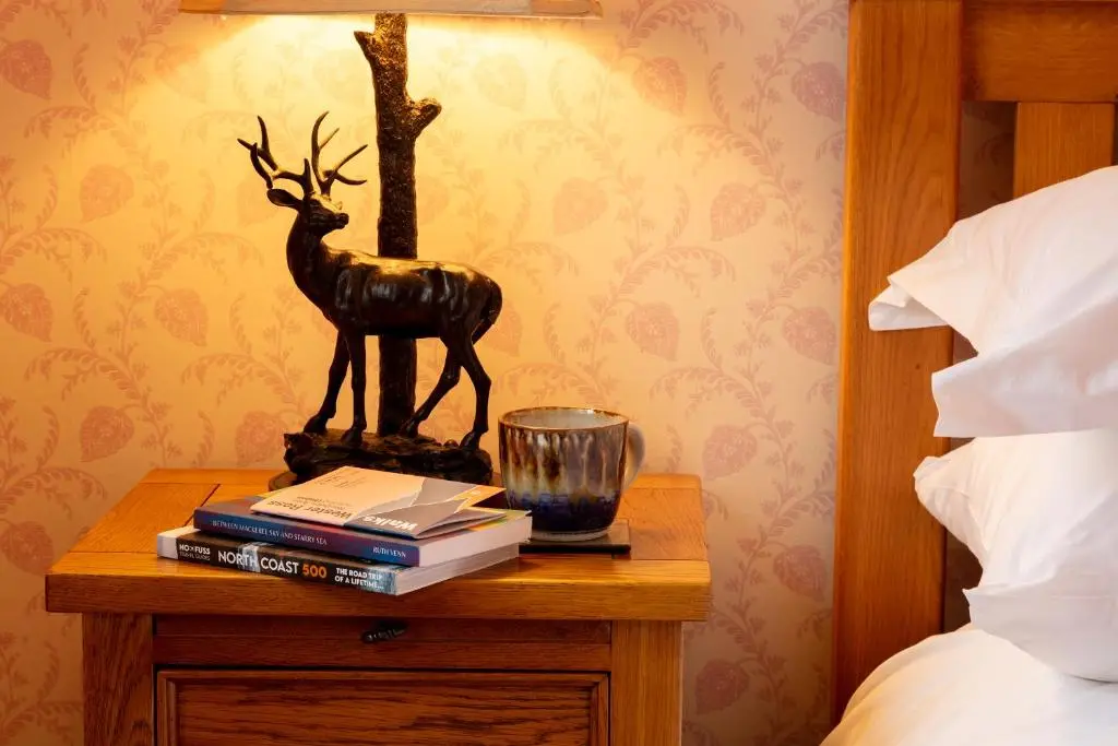 a table with books and a statue of a deer on it at The Ullapool Rooms in Ullapool