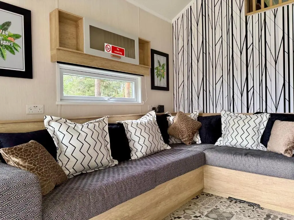 a living room with a couch with pillows at The Parr Pod - Beautiful, luxury pod in Aberlour