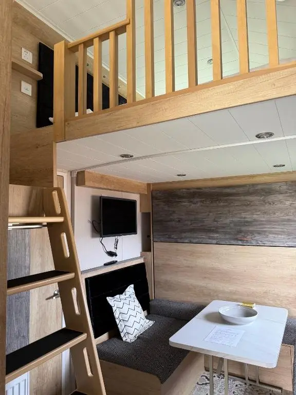 a tiny house with a loft bed and a desk at The Smolt Pod - Beautiful, luxury pod in Aberlour