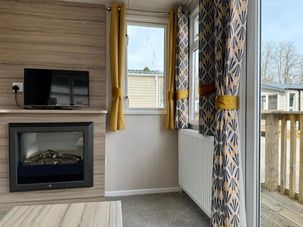 a living room with a fireplace and a tv at The Salmon Van - Beautiful, luxury static caravan in Aberlour
