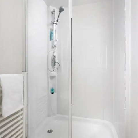 a shower with a glass door in a bathroom at The Fly Van - Beautiful, luxury static caravan in Aberlour