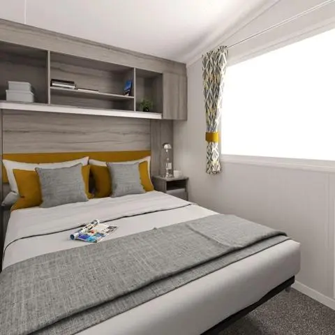 a bedroom with a large bed with a window at The Dram Van - Beautiful, luxury static caravan in Aberlour