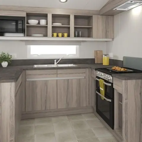 a kitchen with wooden cabinets and a stove top oven at The Dram Van - Beautiful, luxury static caravan in Aberlour