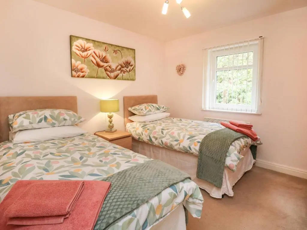 a bedroom with two beds and a window at 4 River Court in Invergarry