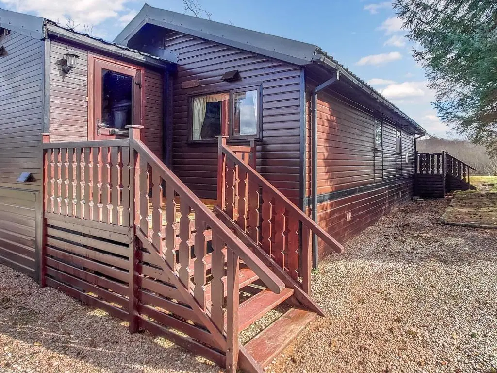 a wooden ramp leading up to a wooden house at 27 Aviemore Holiday Park in Aviemore