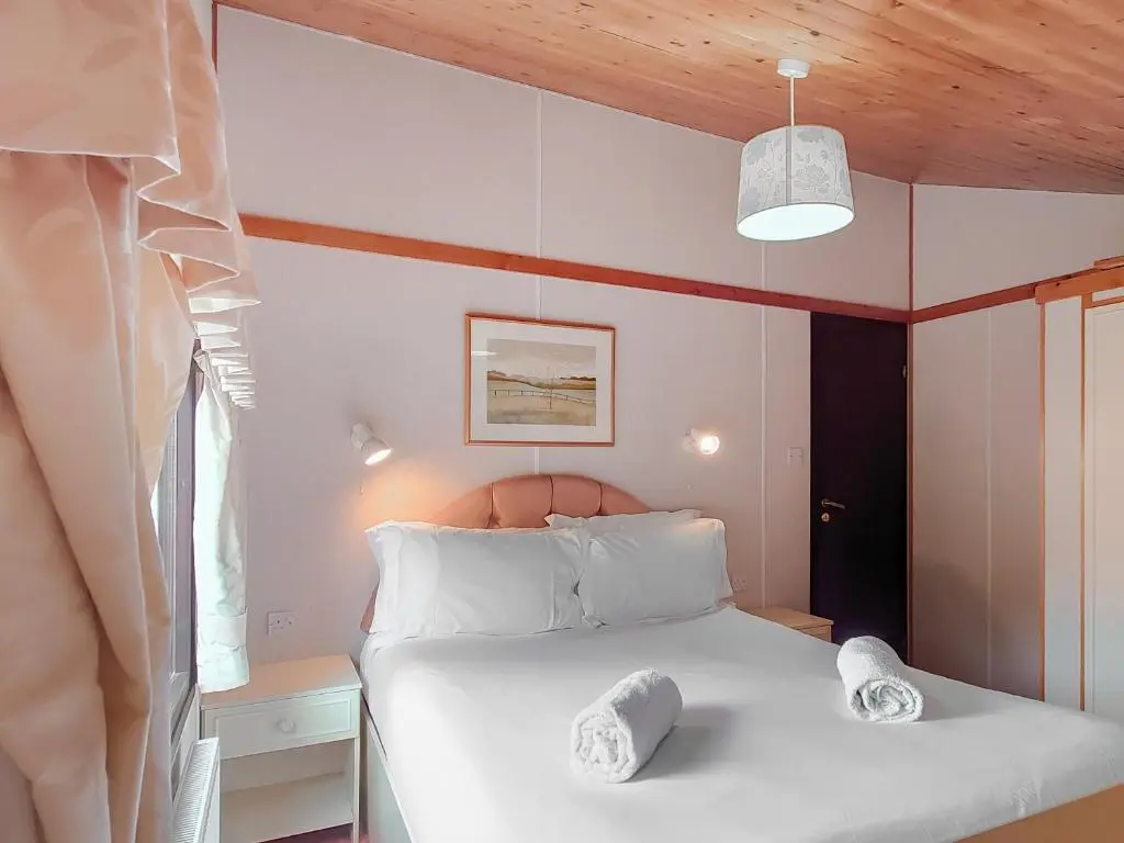 a bedroom with a bed with two pillows on it at 27 Aviemore Holiday Park in Aviemore