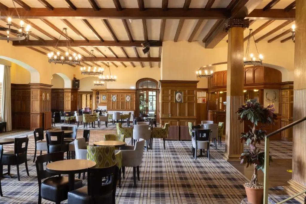 a restaurant with tables and chairs in a building at The Highland Hotel by Compass Hospitality in Strathpeffer