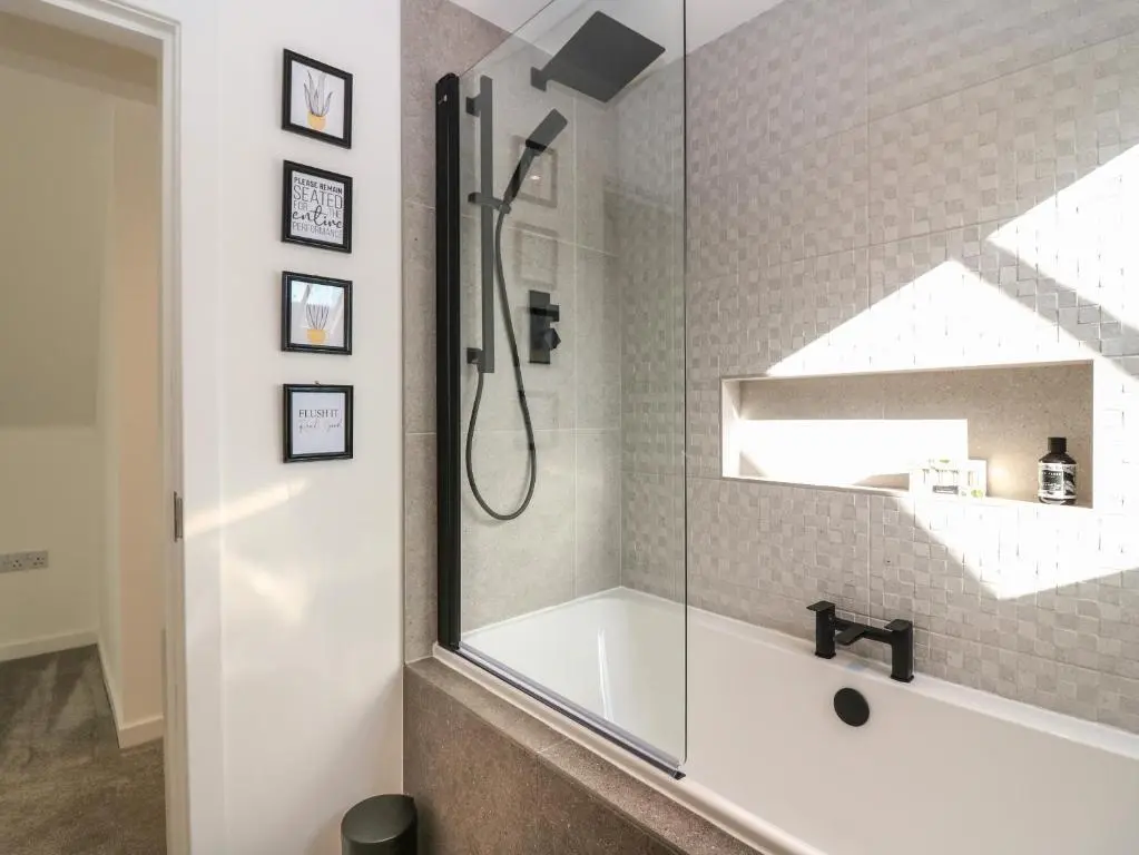 a bathroom with a shower and a bath tub at Bullpens in Banff