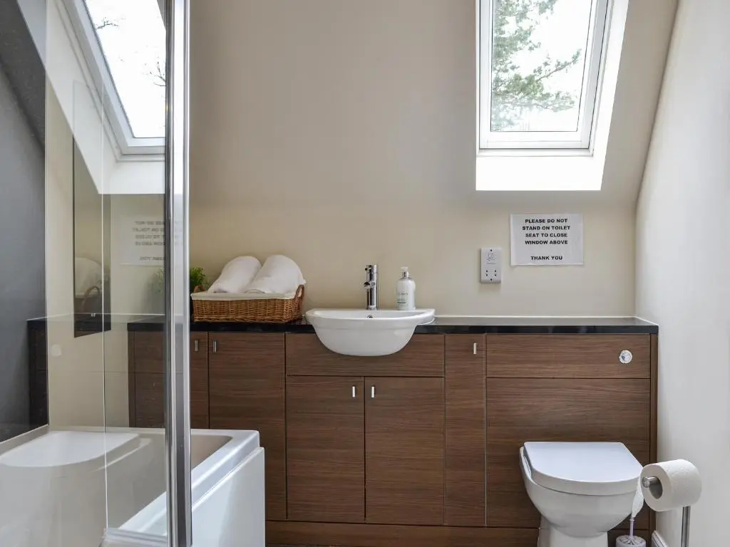 a bathroom with a sink and a toilet and a window at Golf View in Aboyne