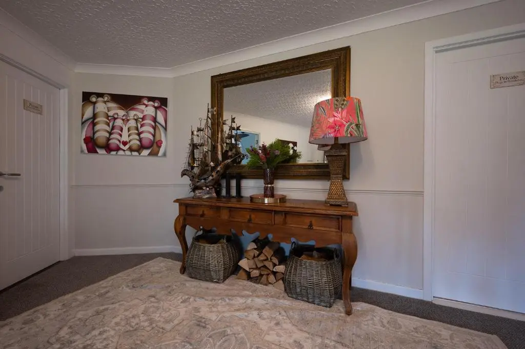 a room with a table with a mirror and a lamp at Balmridge House, Loch Ness, Bed & Breakfast in Drumnadrochit
