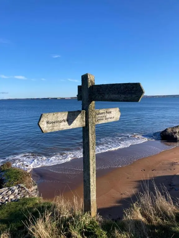 a wooden cross on the beach next to the ocean at Balmridge House, Loch Ness, Bed & Breakfast in Drumnadrochit