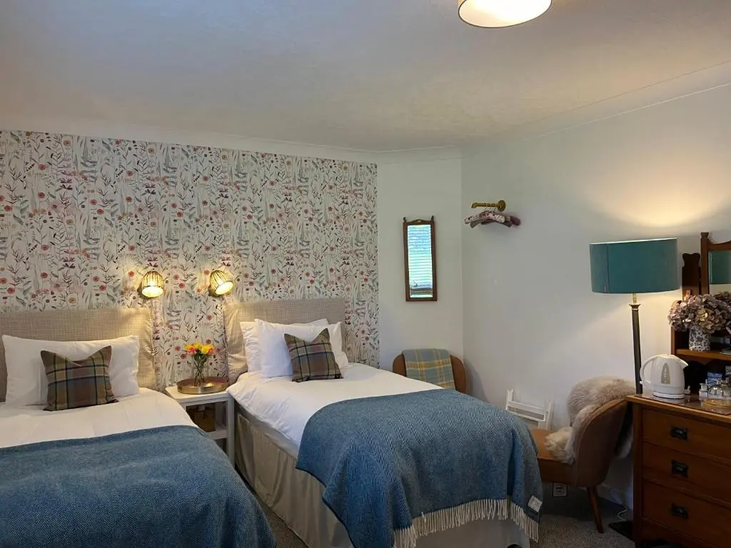 a bedroom with two beds with blue blankets at Balmridge House, Loch Ness, Bed & Breakfast in Drumnadrochit