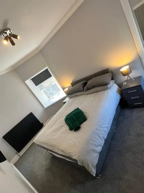 a bedroom with a large bed in a small room at Town centre 2 bed luxury apartment in Wick