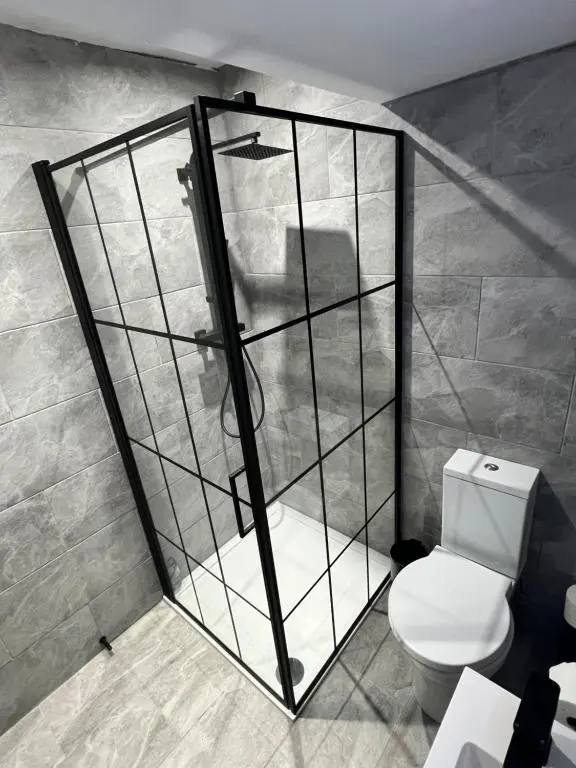 a bathroom with a shower with a toilet in it at Town centre 2 bed luxury apartment in Wick