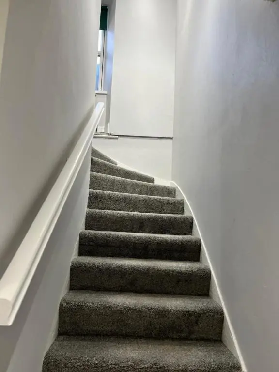 a staircase in a building with a stair case at Town centre 2 bed luxury apartment in Wick