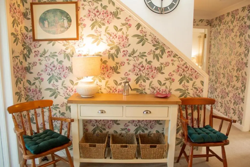 a room with a table and two chairs and a staircase at Longfield, Daviot in Inverness