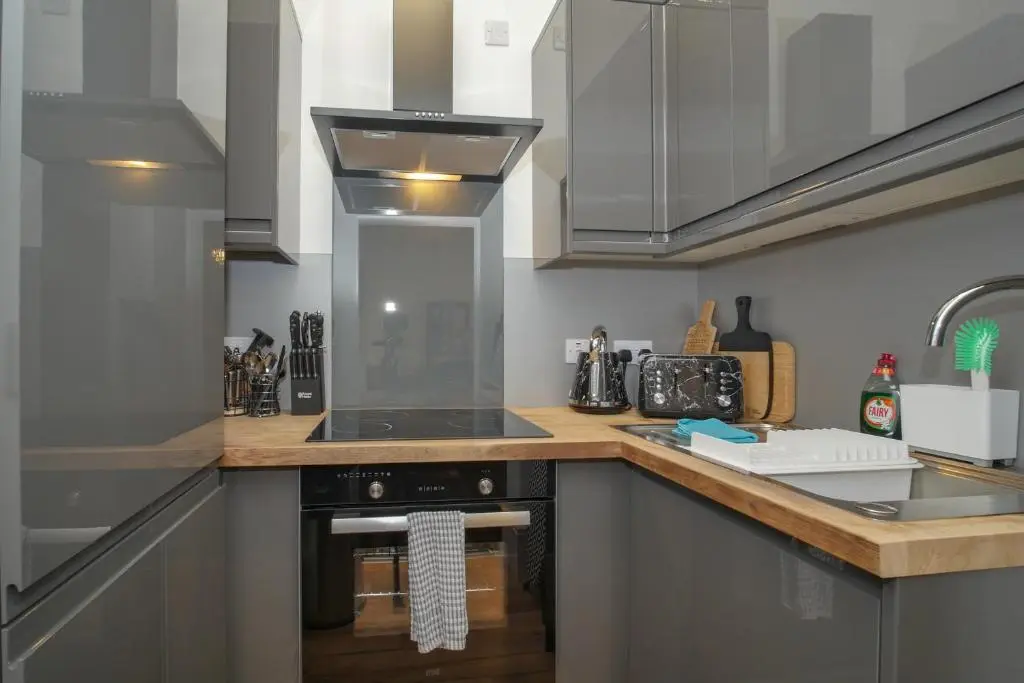a kitchen with a stove top oven next to a sink at Gordonston Apartments in Inverness