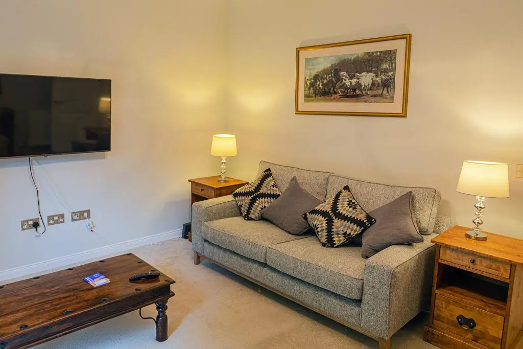 a living room with a couch and a table at Hedgefield House - Serene Top Floor Flat in Inverness