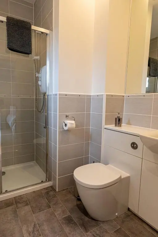 a bathroom with a toilet and a shower at Hedgefield House - Serene Top Floor Flat in Inverness