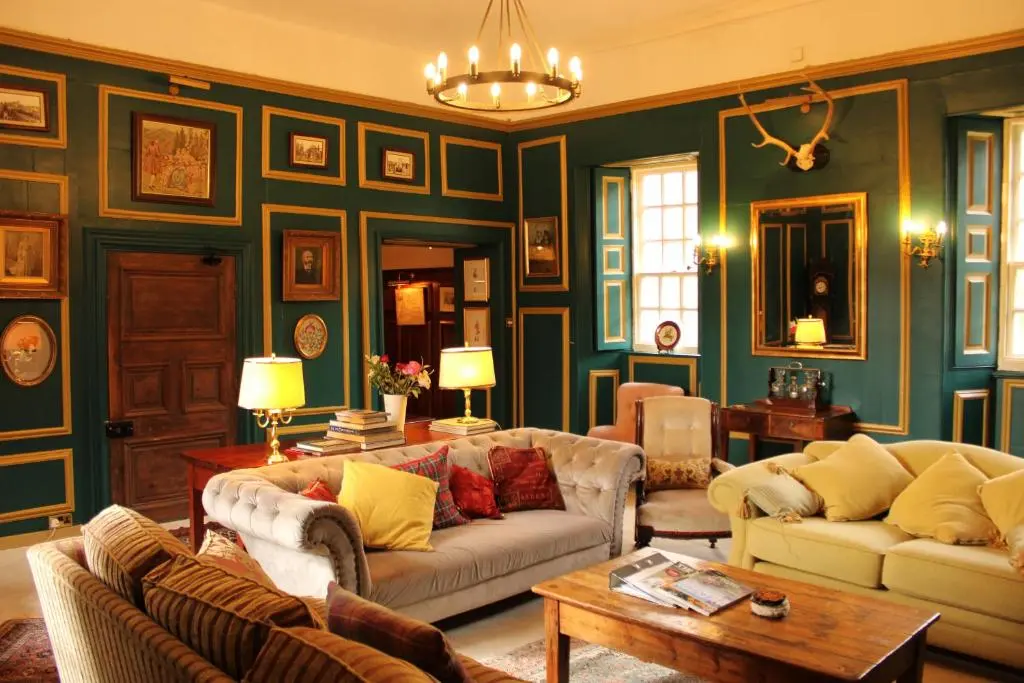 a living room with two couches and a table at West Wing Lickleyhead Castle in Auchleven