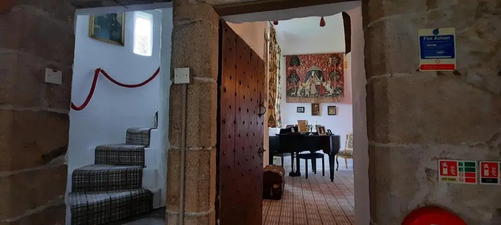 a hallway with a staircase and a table in a room at West Wing Lickleyhead Castle in Auchleven