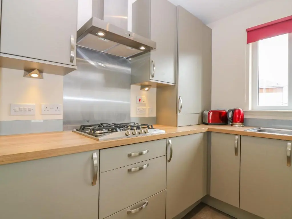 a kitchen with white cabinets and a stove top oven at 10 Goodhope Gardens in Aberdeen