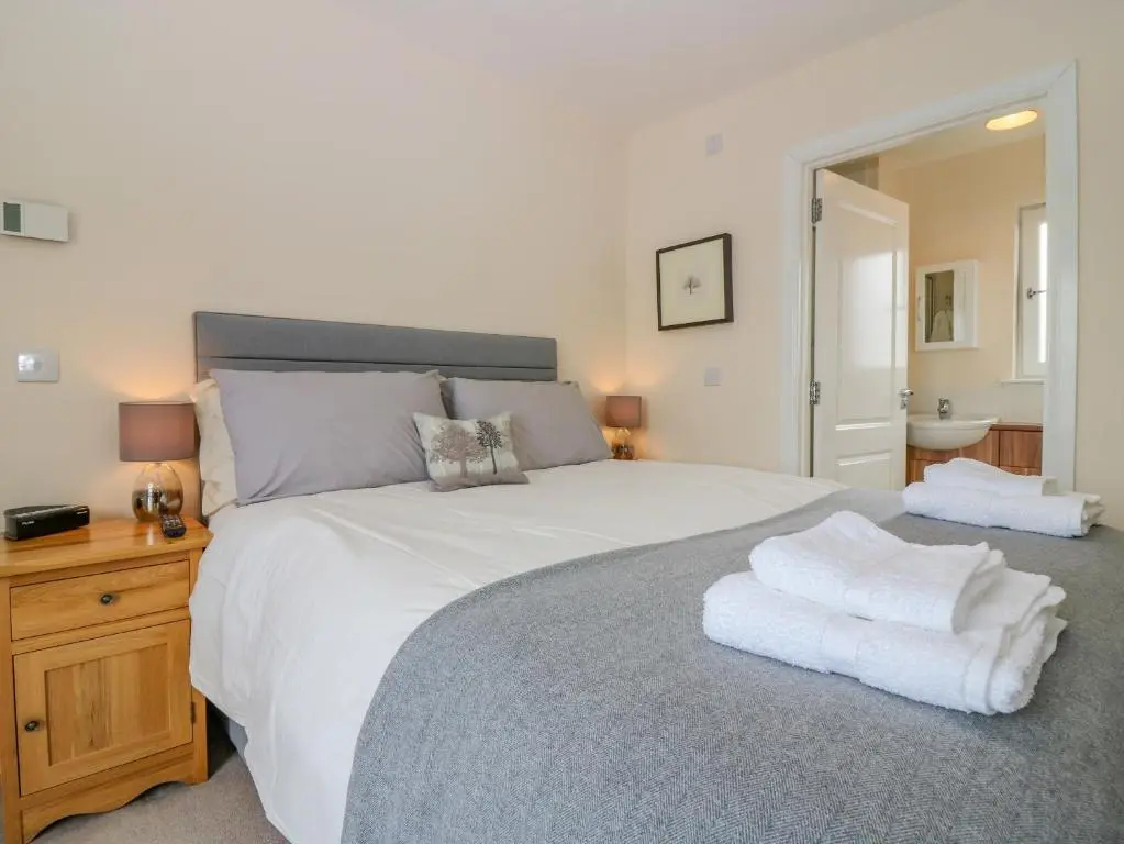 a bedroom with a large white bed with towels on it at 10 Goodhope Gardens in Aberdeen