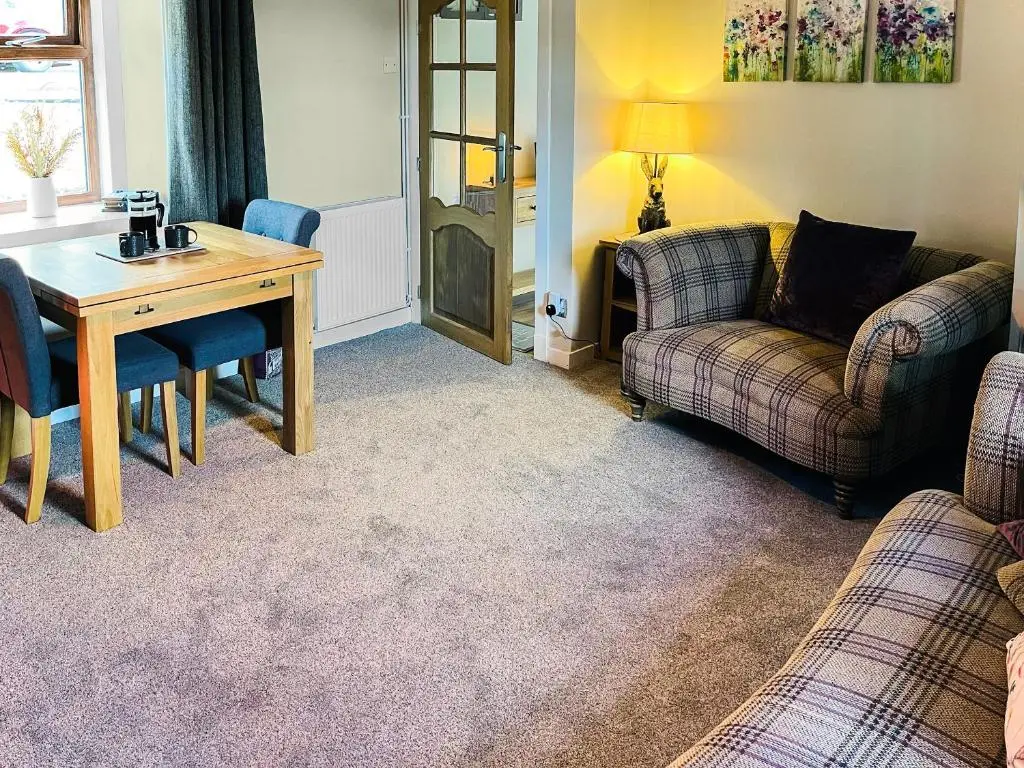 a living room with a table and a couch at Portknockie Escape in Portknockie