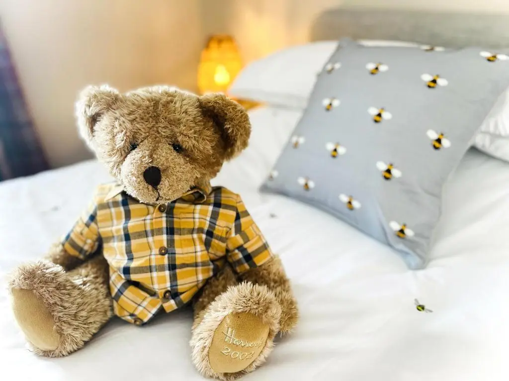 a brown teddy bear sitting on a bed at Portknockie Escape in Portknockie