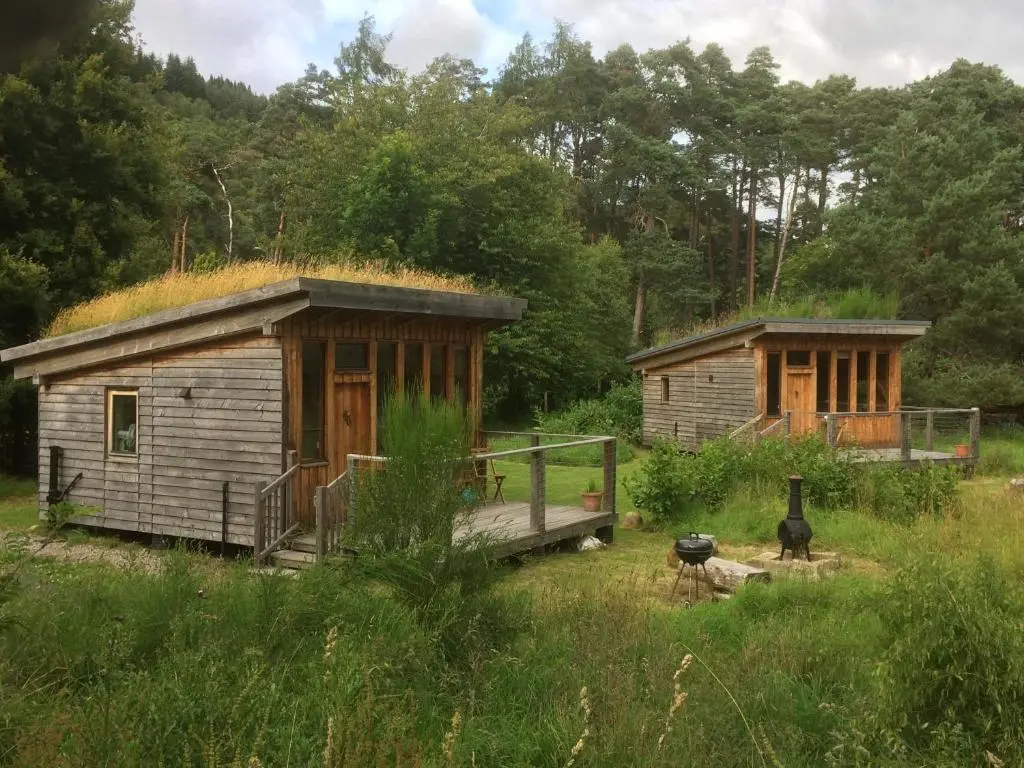 a small cabin with a grass roof and a grill at Caledonian Glamping in Cannich