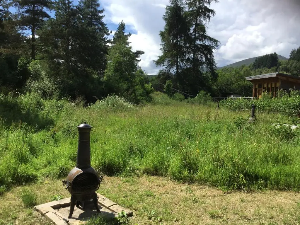a fire hydrant sitting in the middle of a field at Caledonian Glamping in Cannich