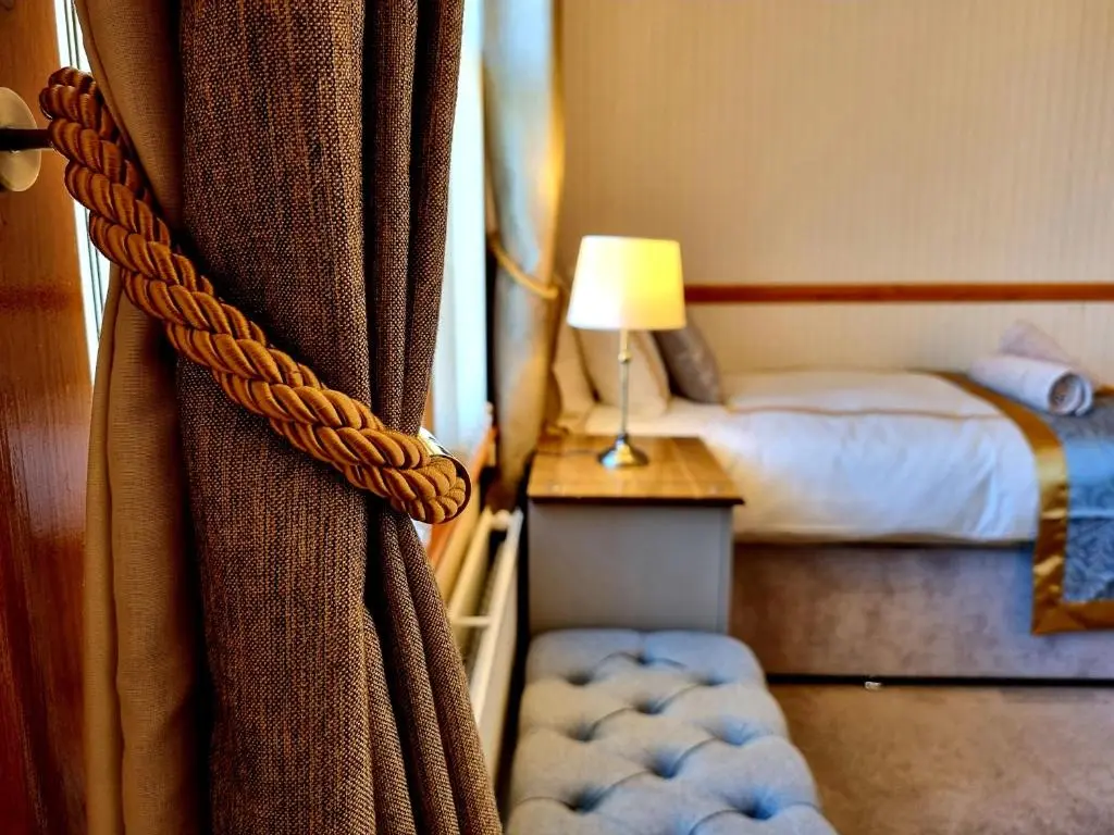 a hotel room with a curtain and a bed at Inverness City 3 bedroom house free parking in Inverness