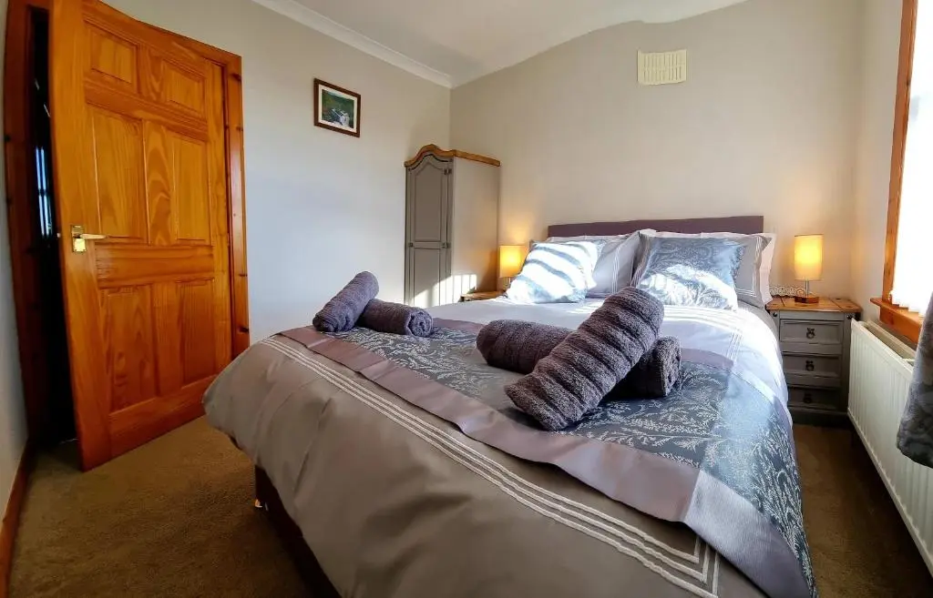 a bedroom with a large bed with pillows on it at Inverness City 3 bedroom house free parking in Inverness