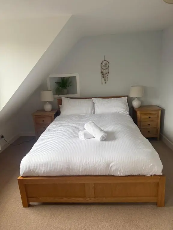 a bedroom with a bed with two towels on it at Riverside Cottage City Centre in Inverness