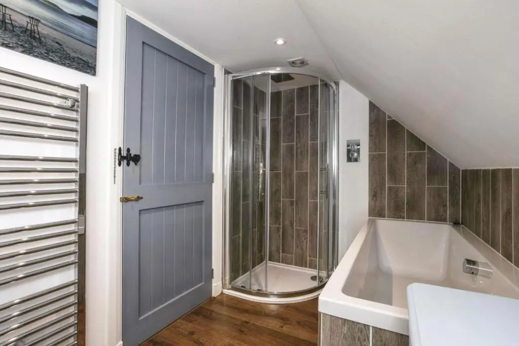 a bathroom with a shower and a bath tub at 29 Seafield Street in Whitehills