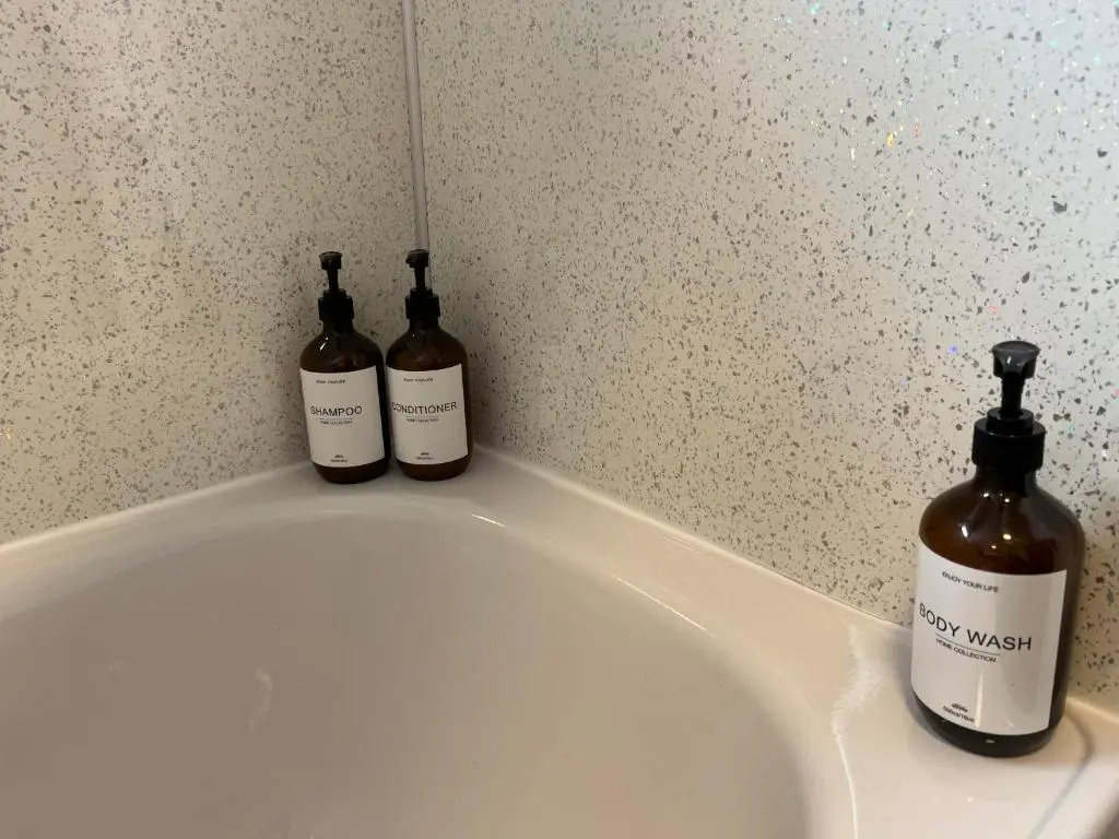 two bottles of wine sitting on top of a white tub at The Wee Hoose near Loch Ness, private garden, private parking in Drumnadrochit
