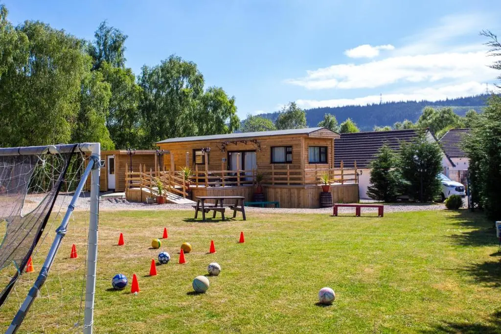 a group of balls on the grass in front of a house at Highland Retreats Cannich in Cannich