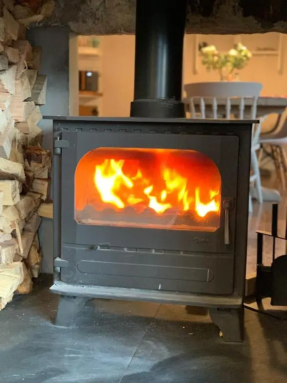a stove with a fire inside of it at Highland Hideaway in secluded riverside location in Garve