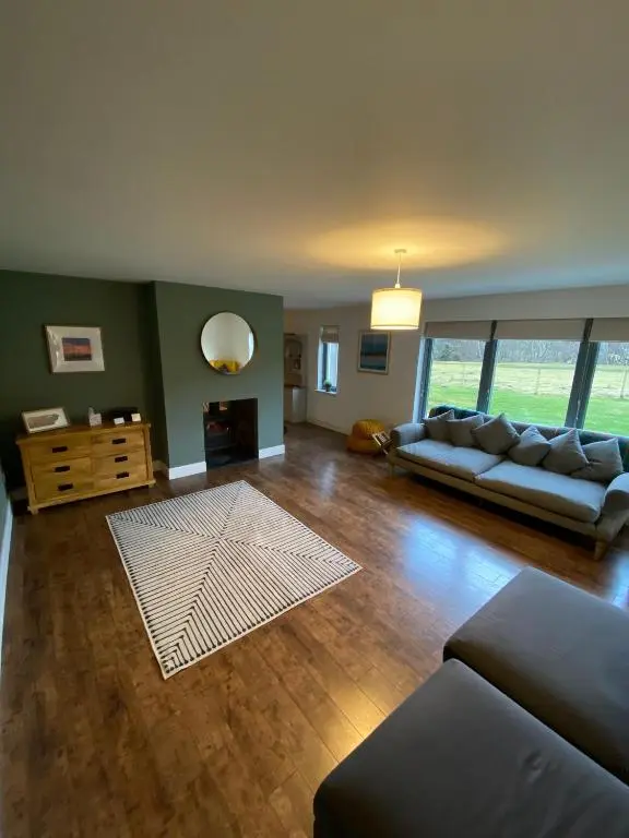 a living room with a couch and a table at Highland Hideaway in secluded riverside location in Garve