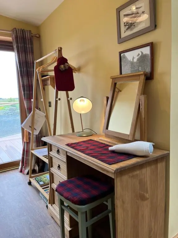 a dressing room with a desk with a mirror and a stool at The Stable - NC500 in Wick