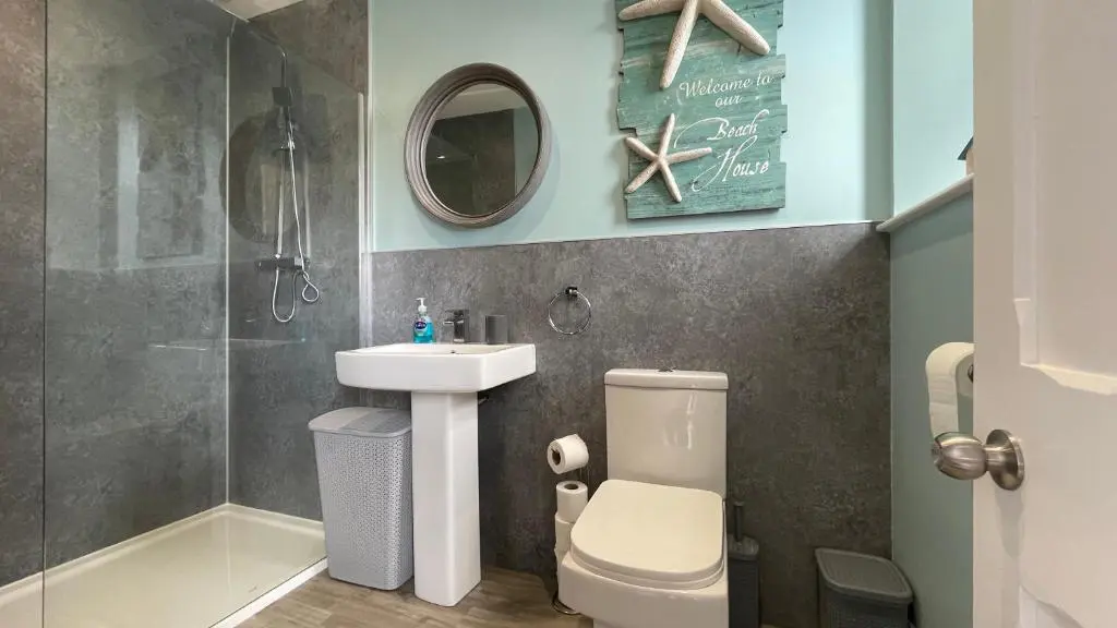 a bathroom with a sink and a toilet and a mirror at The Store by Caithness Luxury Apartments NC500 - Luxury modern conversion with open plan living - Sleeps 4 in Wick