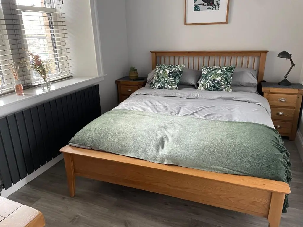 a bed with a wooden frame in a bedroom at The Store by Caithness Luxury Apartments NC500 - Luxury modern conversion with open plan living - Sleeps 4 in Wick