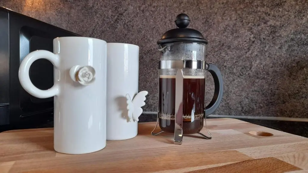 a blender sitting on a table next to two white cups at Beauly Holiday Home in Beauly