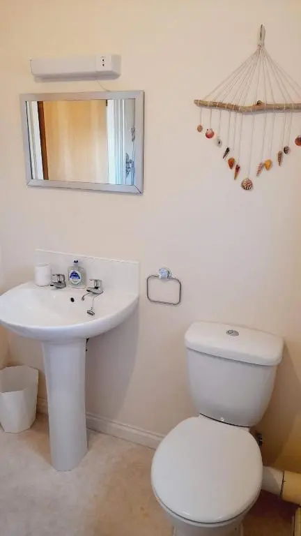 a bathroom with a toilet and a sink and a mirror at Beauly Holiday Home in Beauly