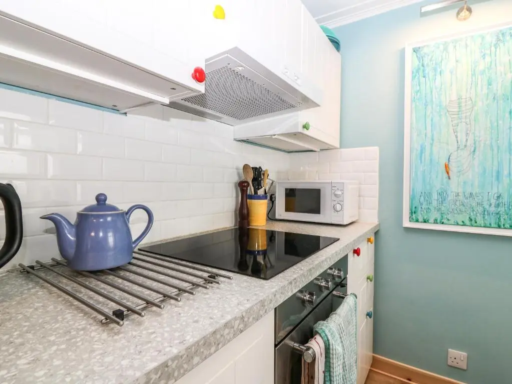 a kitchen with a stove with a tea kettle on it at Dookers' Hoose in Buckie