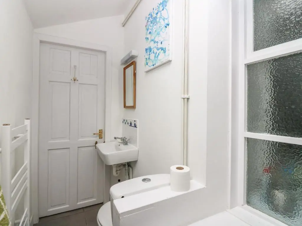 a white bathroom with a toilet and a sink at Dookers' Hoose in Buckie