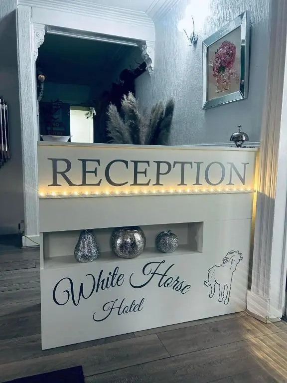 a sign for a white horse hotel in a room at White Horse Hotel in Strichen